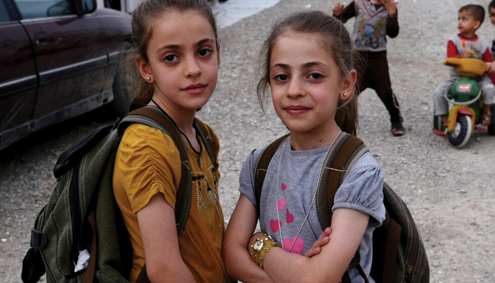 Two little girls looking at the camera smiling