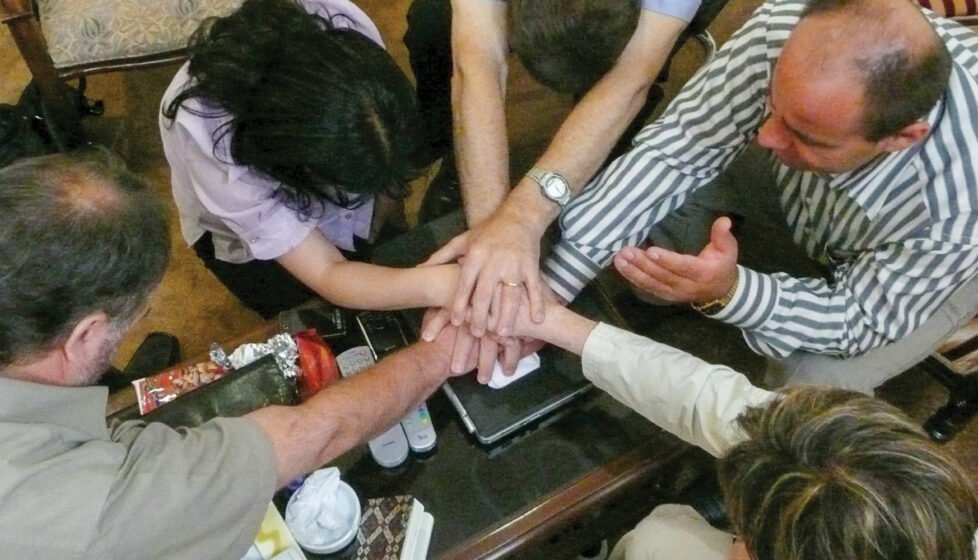 A group of people sit together and pray
