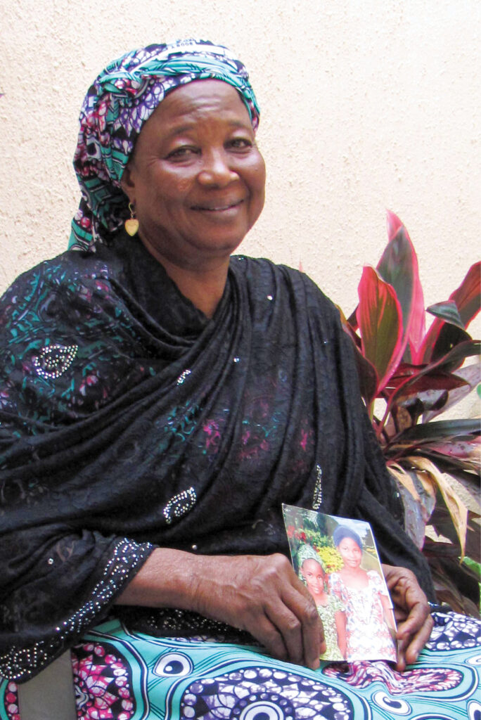 A woman sits with a photo of her two children