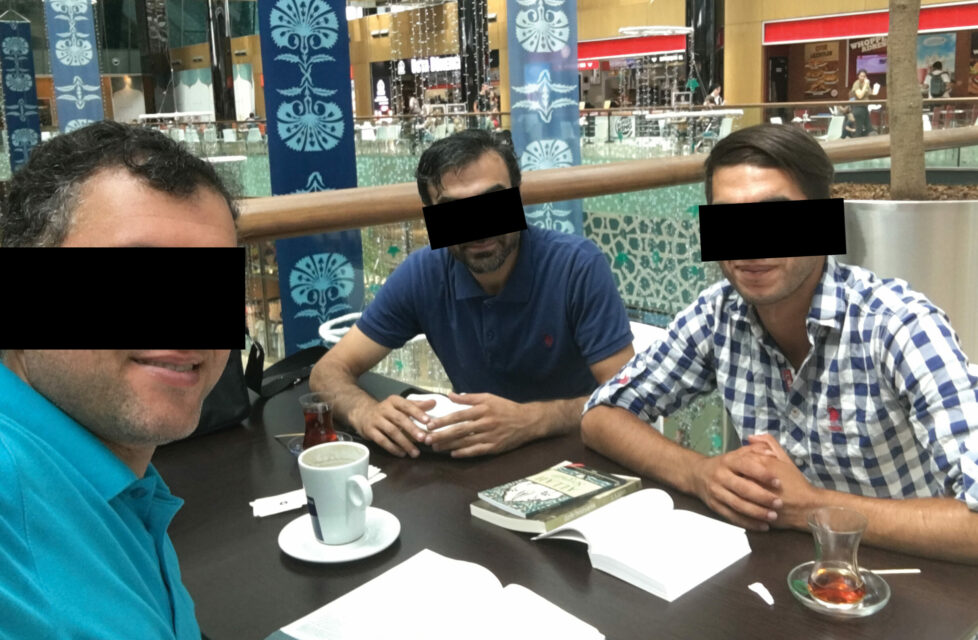 Three men sitting having coffee and reading the Bible