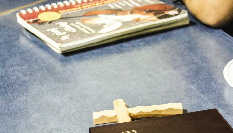 a bible and a cross sitting on a table