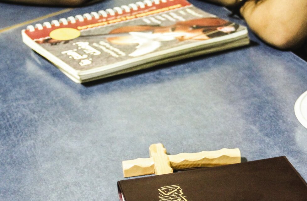a bible and a cross sitting on a table