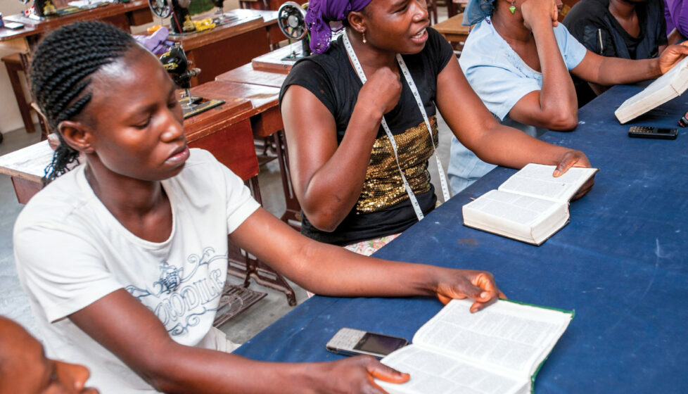 Women sitting at a table reading the Bible and talking