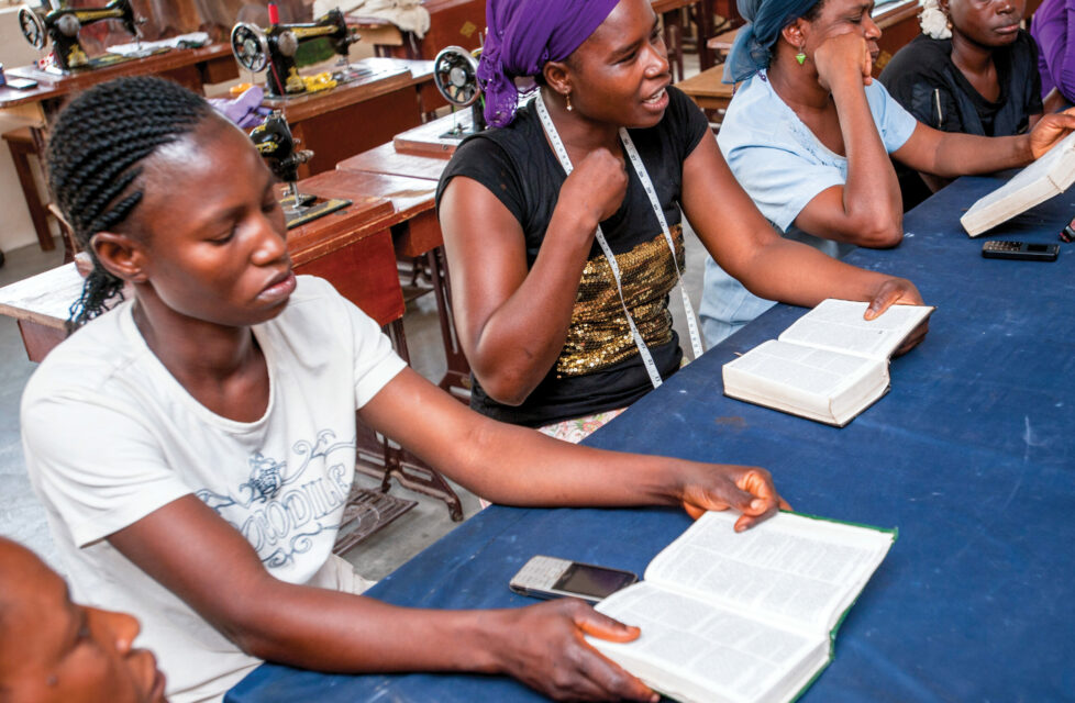 Women sitting at a table reading the Bible and talking