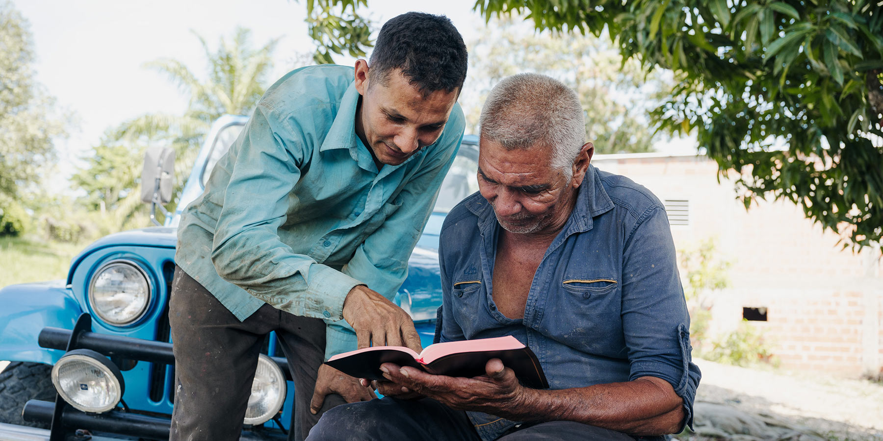 Two men reading a bible.