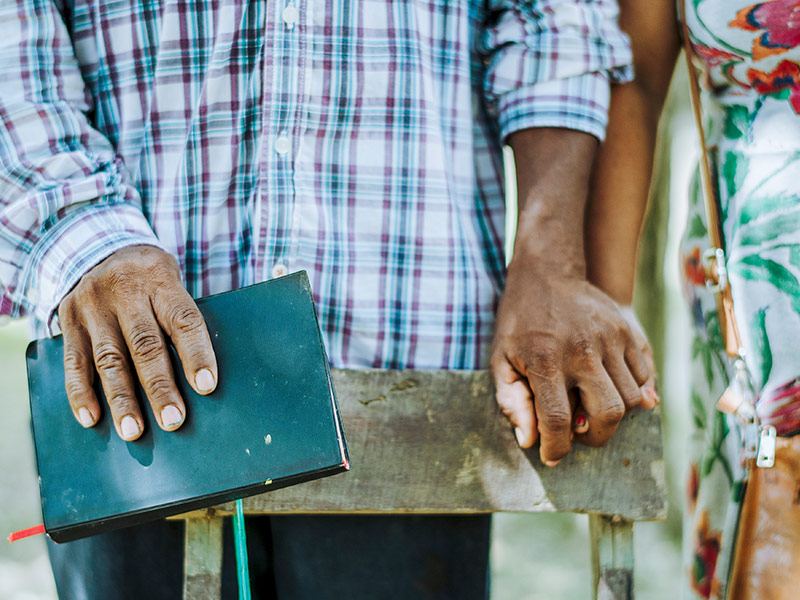 Couple holding hands and holding a Bible