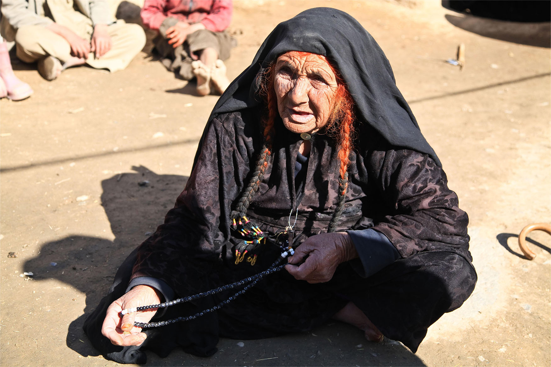 Elderly person sitting on the ground