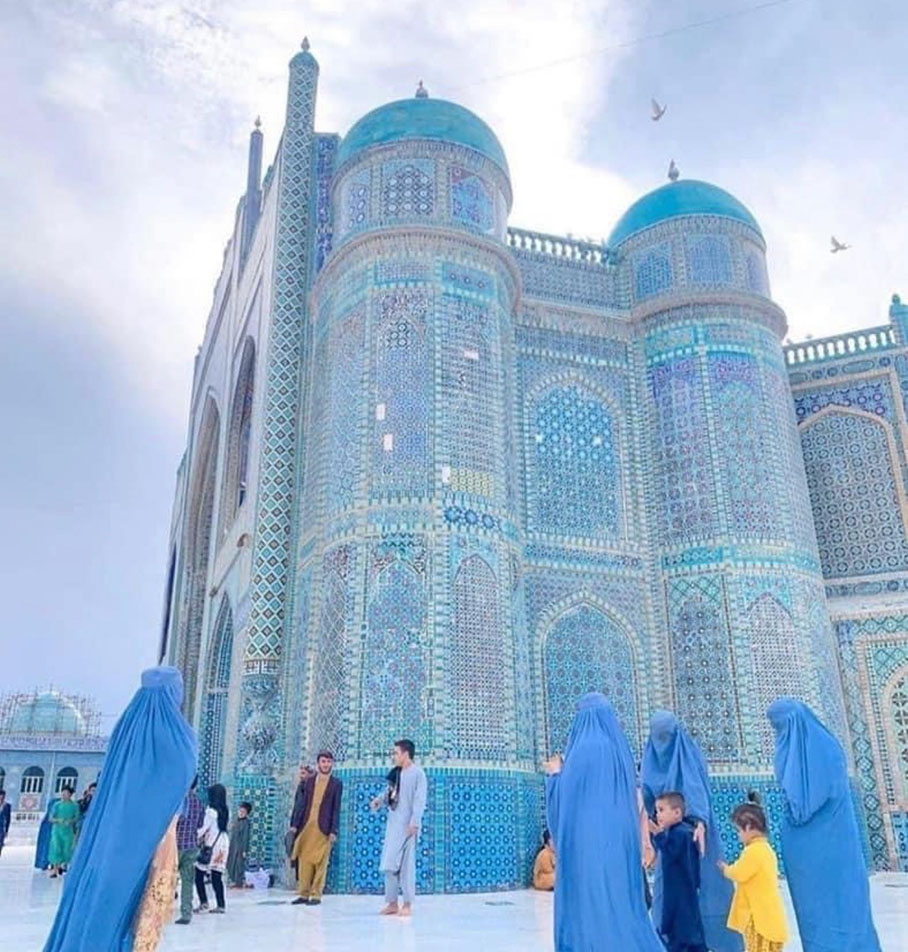 Teal coloured mosque with people in front of it