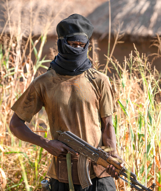 Man with black cloth covering his face and holding a gun