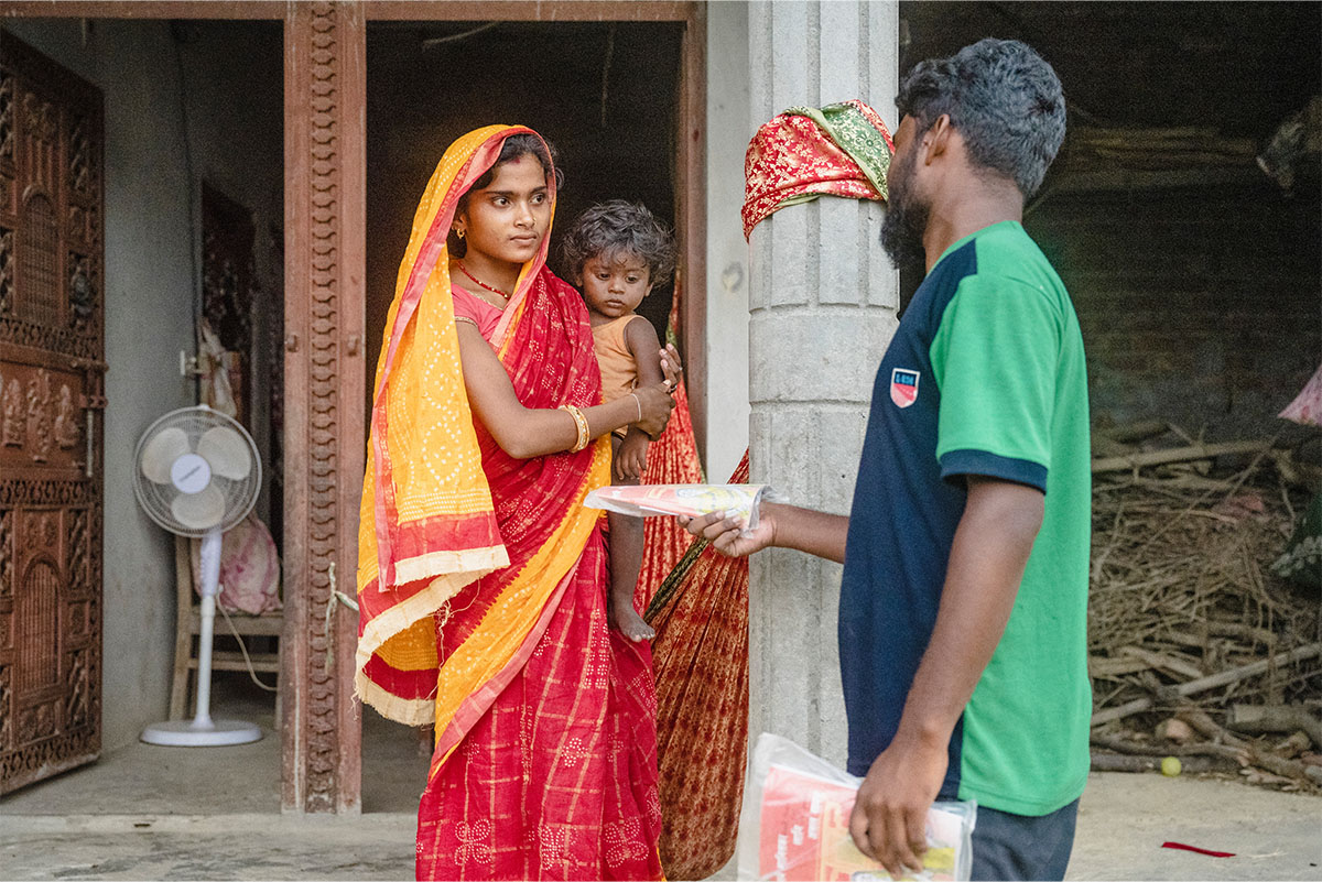 Man handling papers to Woman with child