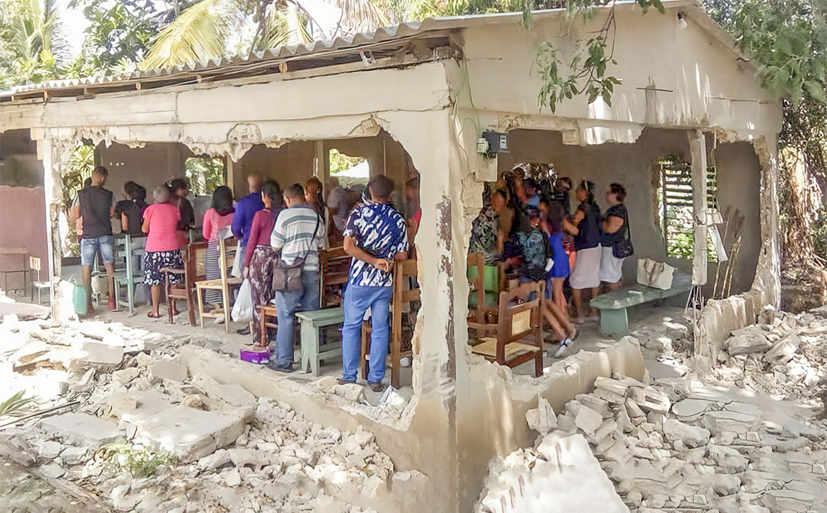 People having church service in building with walls blown out