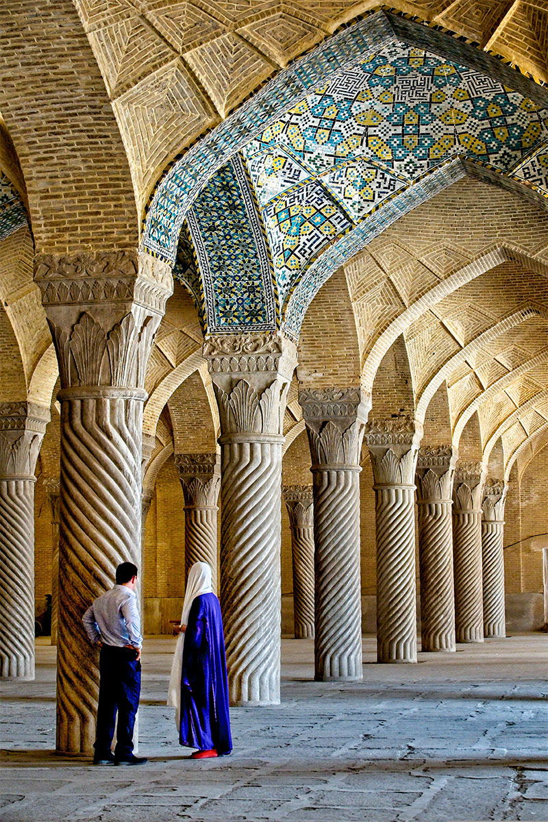 Two people standing inside of a mosque