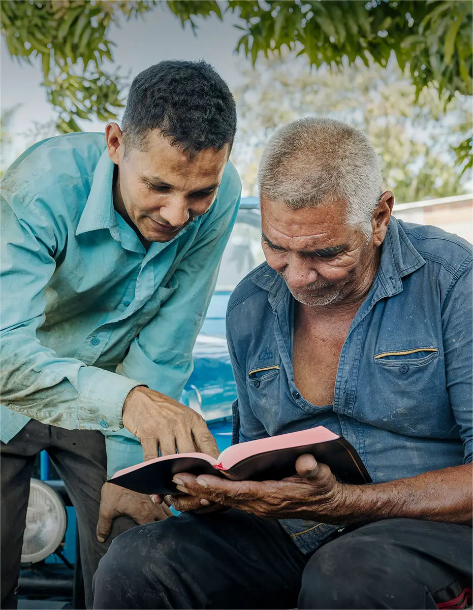 Two men reading a Bible together