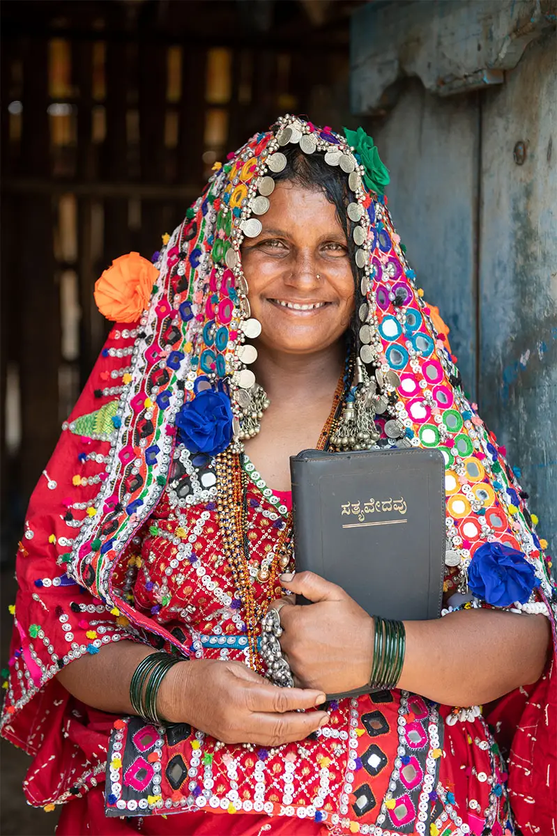 Mujer con ropa colorida sosteniendo una Biblia