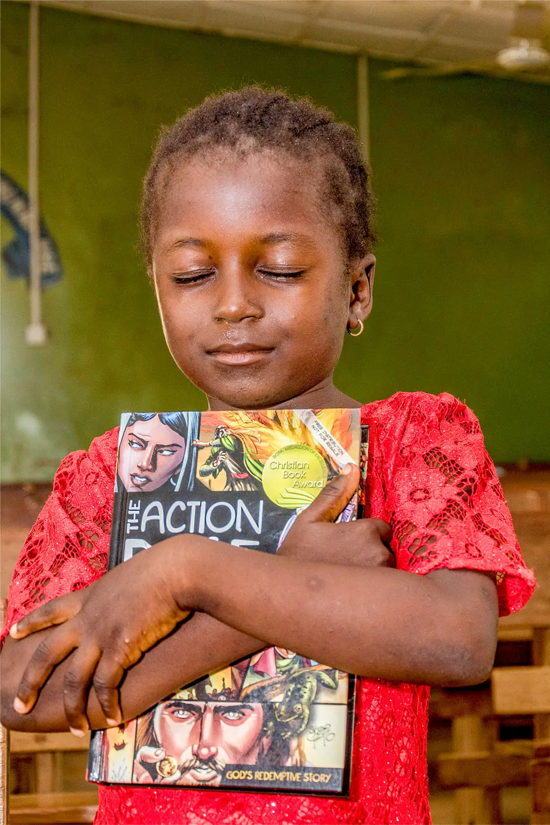 Child hugging Bible