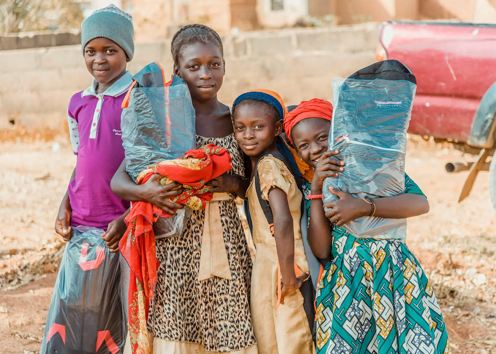 Group of children holding supply bags