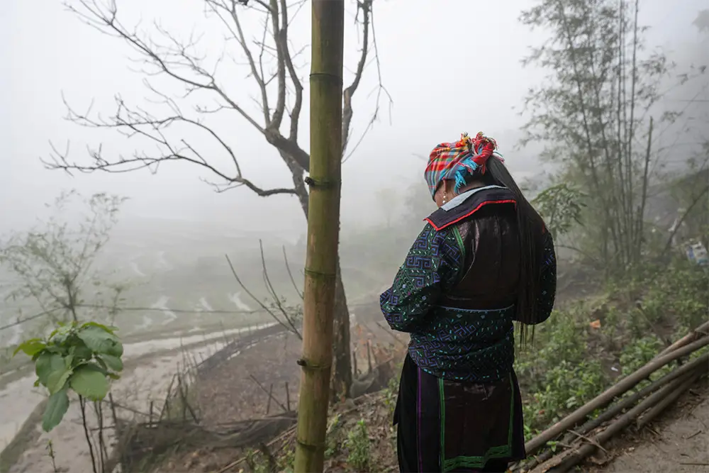 Woman in looking out over foggy mountain hillside