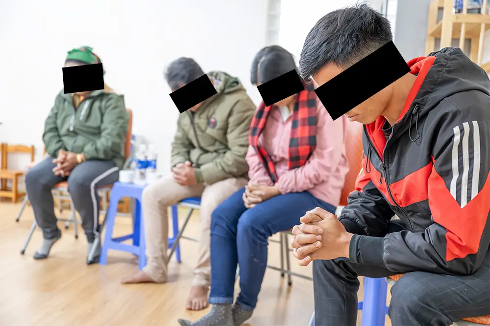 Group of people praying in a room