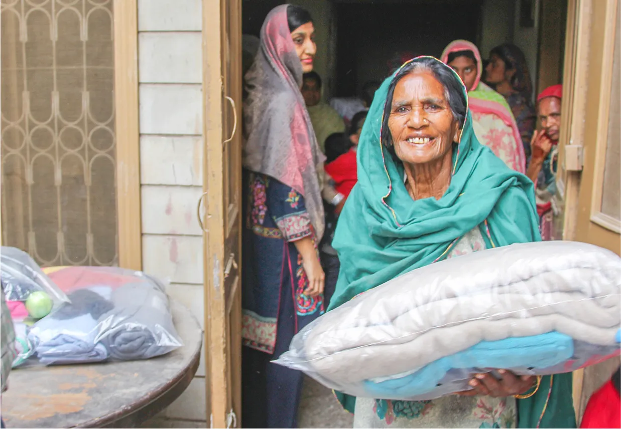 Woman carrying blankets and other supplies