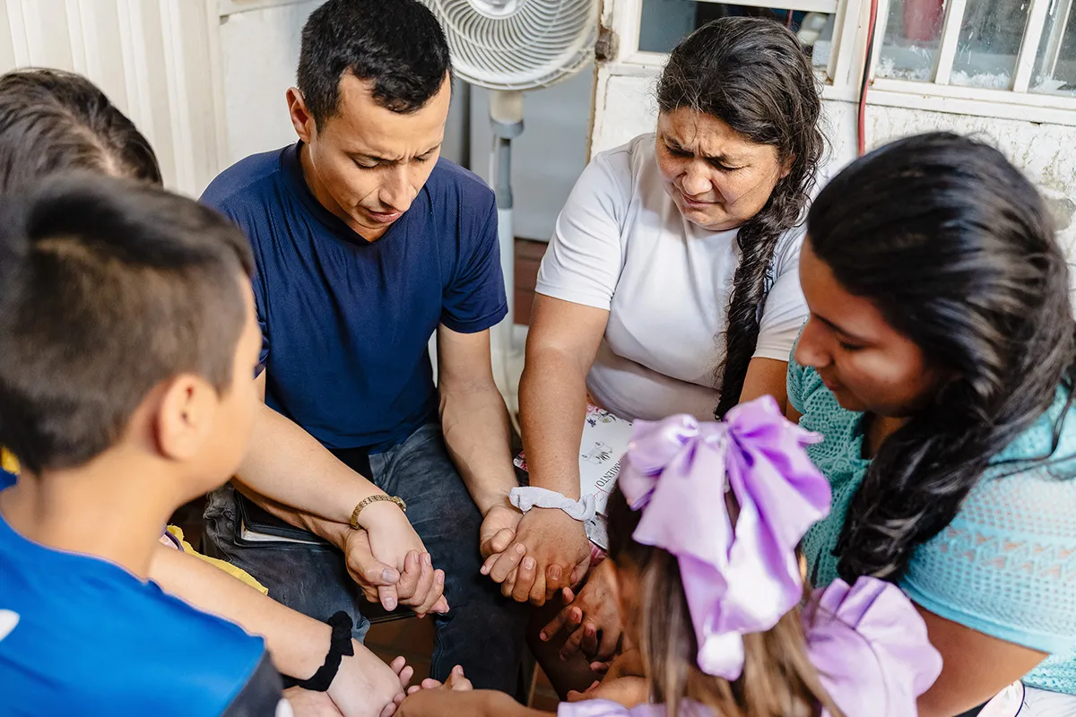 Group of people holding hands and praying