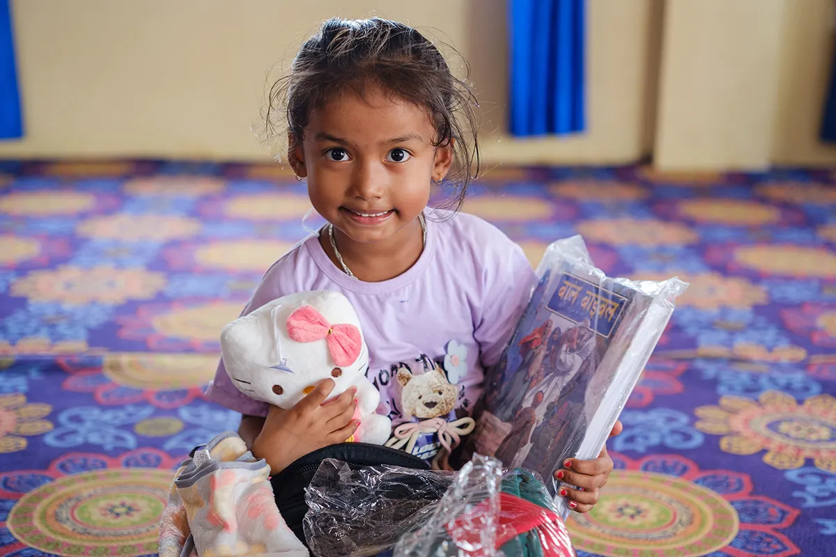 Girl smiling as she opens backpack