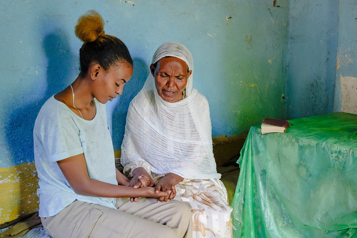 Older and younger women praying together