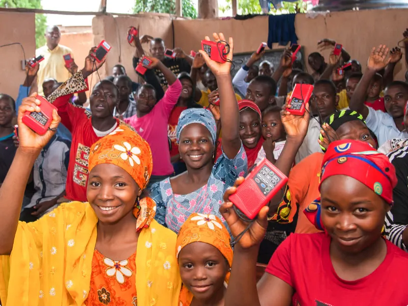 Group of people holding up audio Bibles