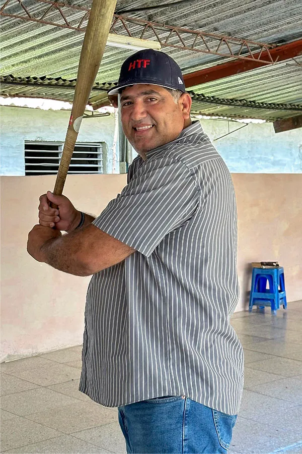 Joel poses holding a baseball bat