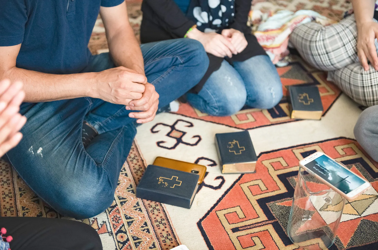Group of people sitting on floor with Bibles