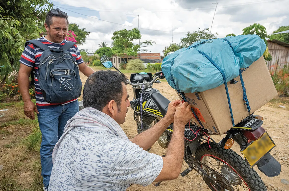 Men loading motorcycle with boxes of Bibles