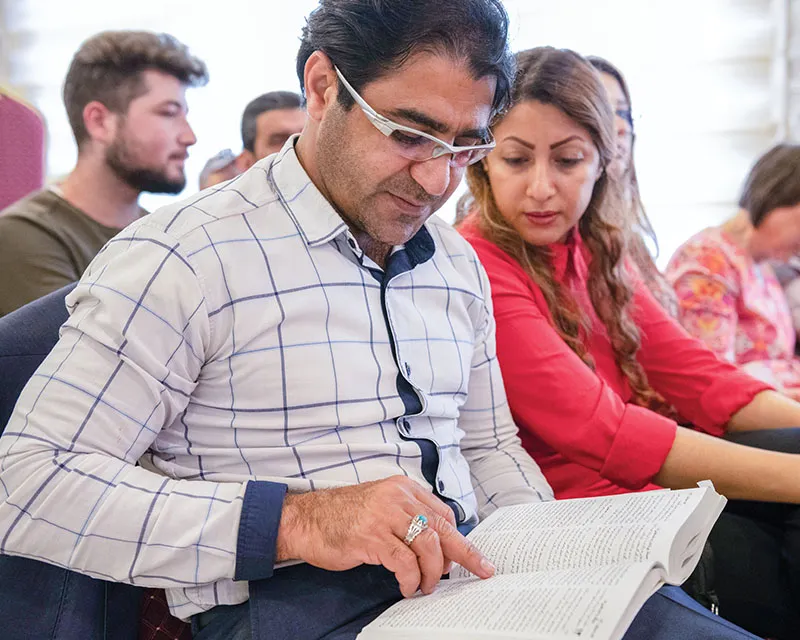 Man reading a Bible in crowd