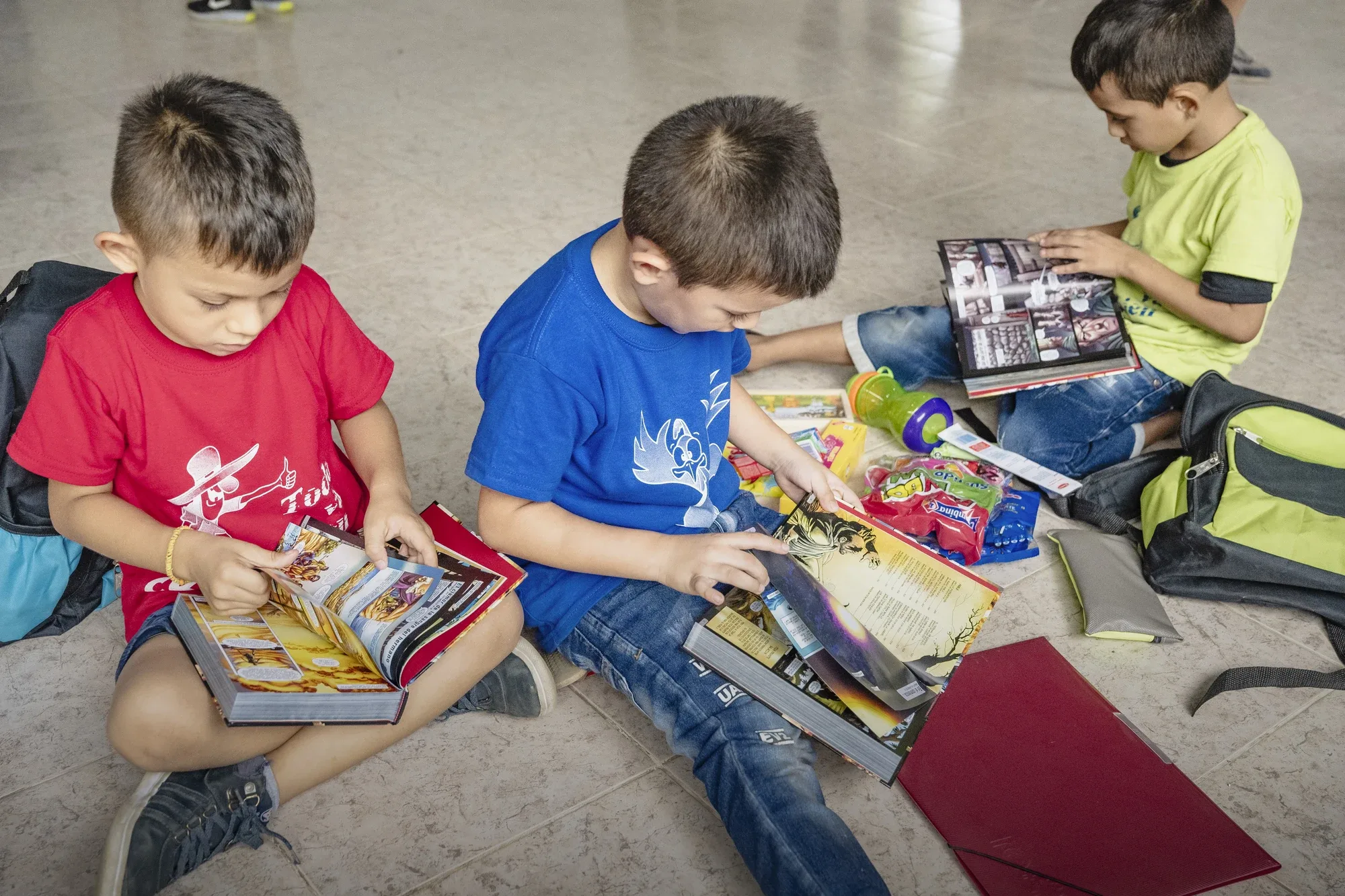 Children exploring illustrated Bibles and gifts from their Christmas Care Packs