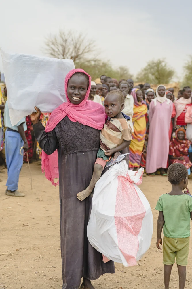 A woman carrying supplies in a bag