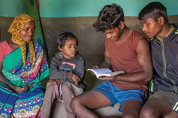 Family seated together while reading a Bible