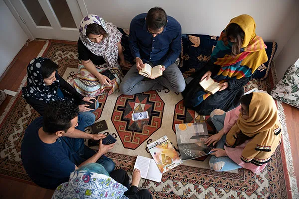 Small group seated on the floor reading Bibles together
