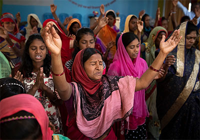 Grupo de personas levantando las manos en adoración