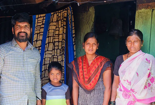 Family posing in front of a house