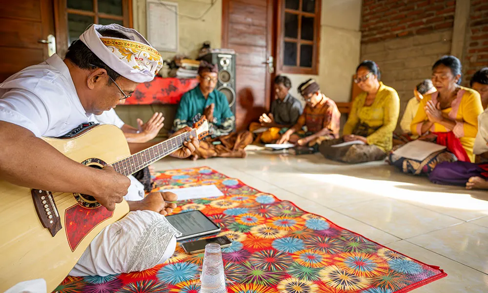 Man playing guitar with group of people