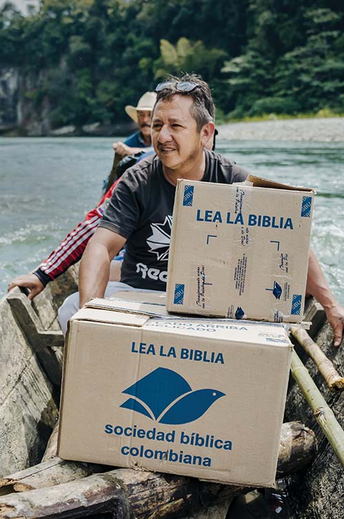 Man in canoe with boxes of bibles