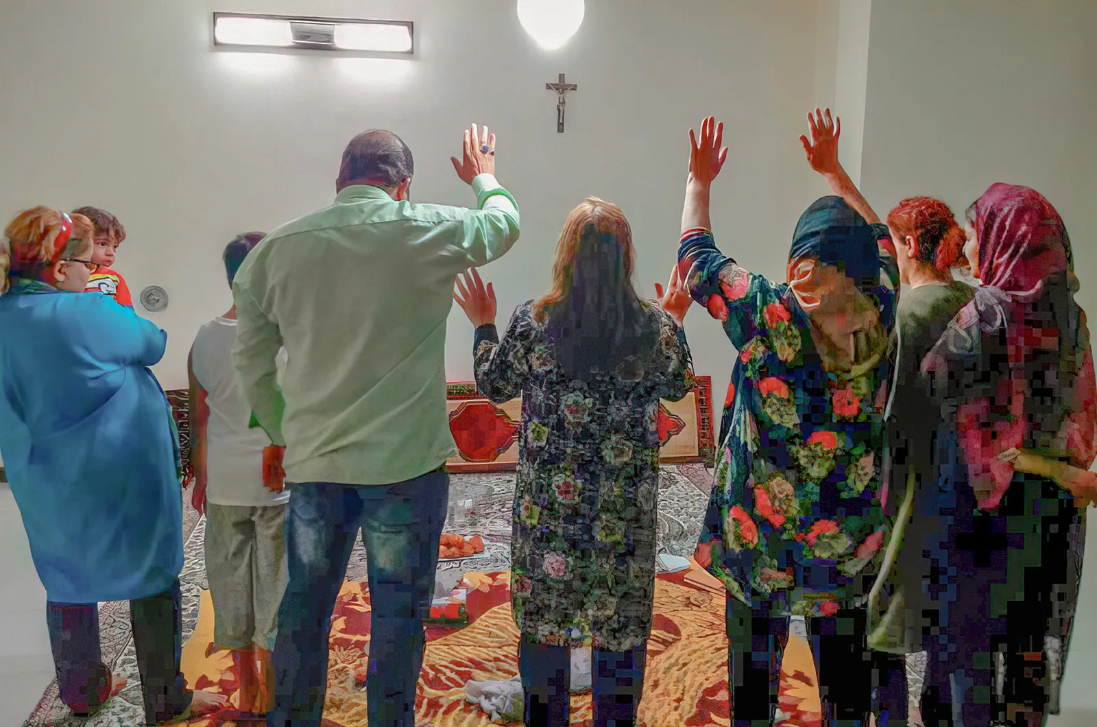 Group praying in a room in front of a cross
