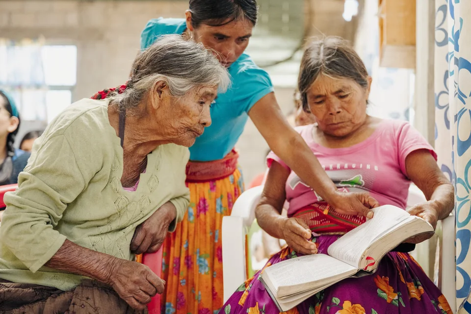 Women reading an open Bible together