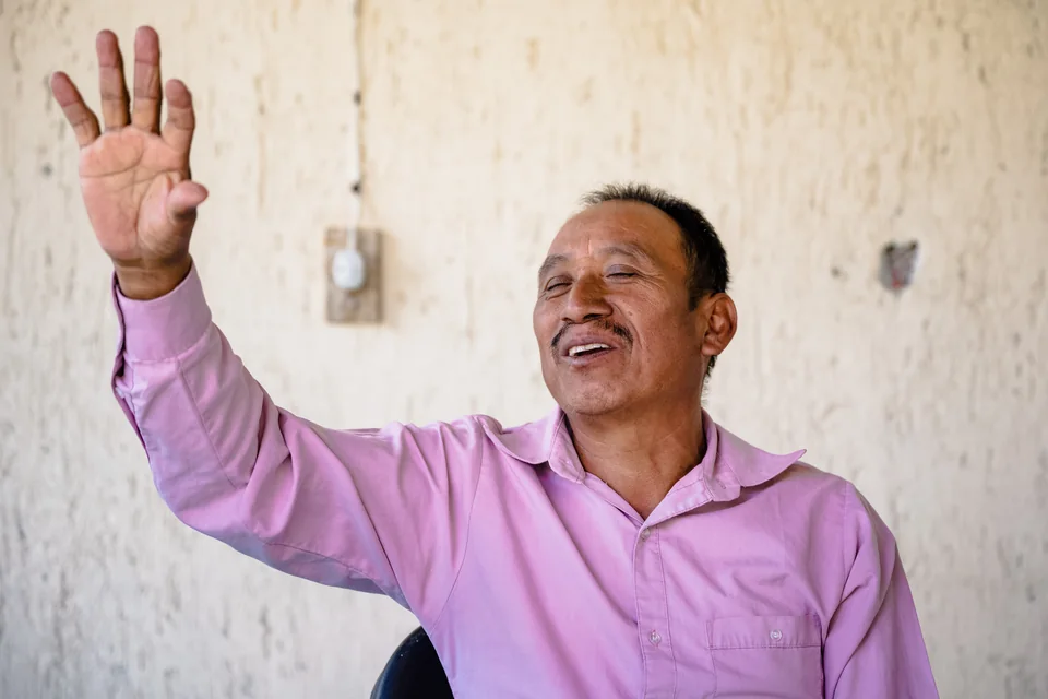 A man with his eyes closed and one hand raised in worship