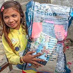 Girl smiling and holding action pack