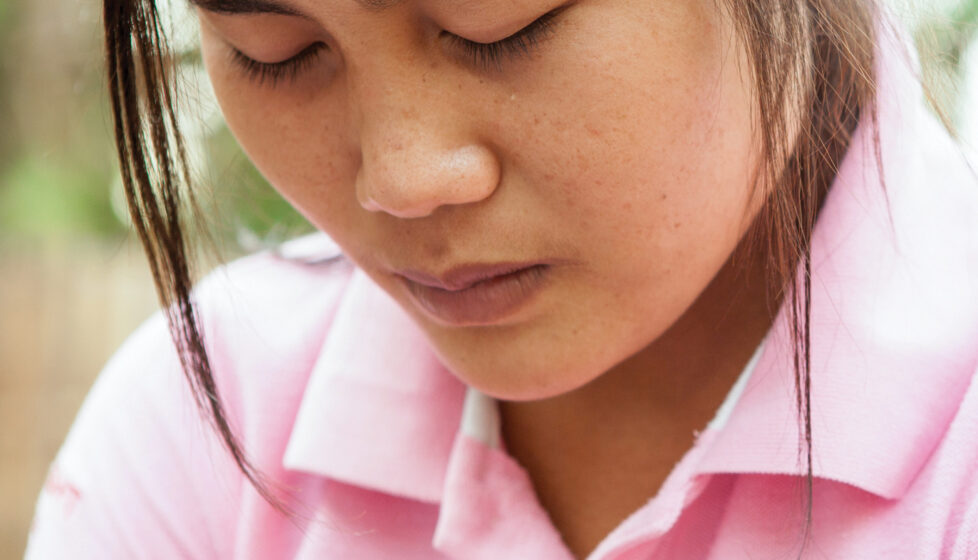 An up close picture of a woman praying