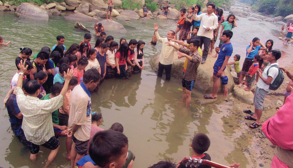 A large group of people worshipping in a river