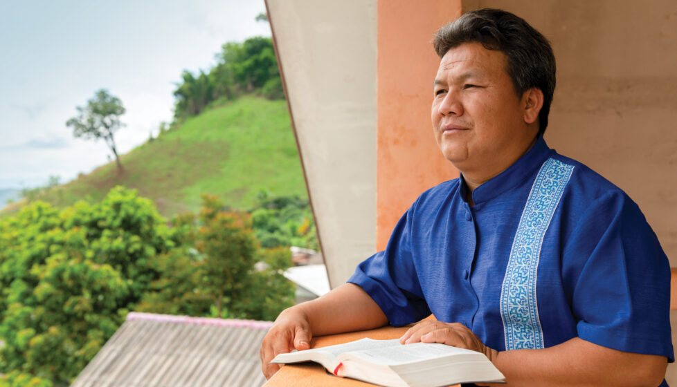 A man sitting on his porch reading the Bible