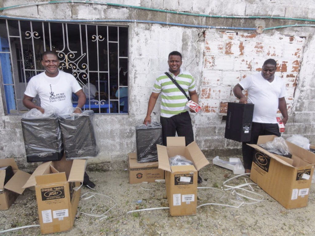 supply boxes with three guys smiling 