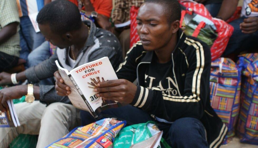 a man sits outside and reads his bible