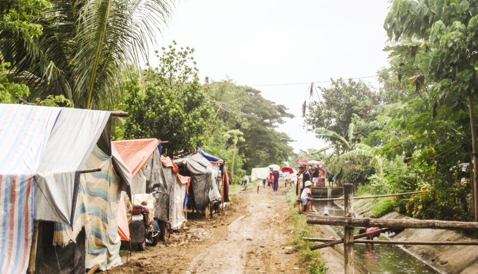 a dirt road with tents on the side