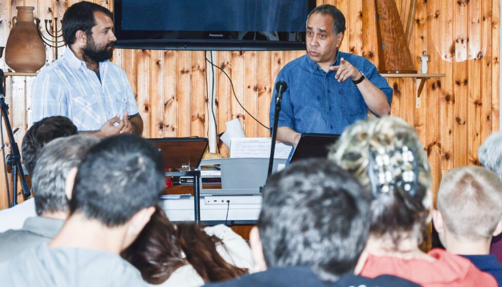 a man stands in front of a group of people at church and preaches